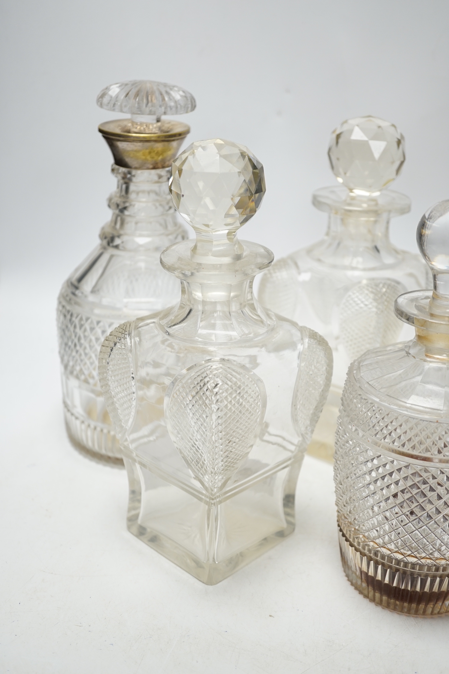 Two silver mounted glass decanters, a pair of waisted cut glass decanters and one other, tallest 29cm high (5)